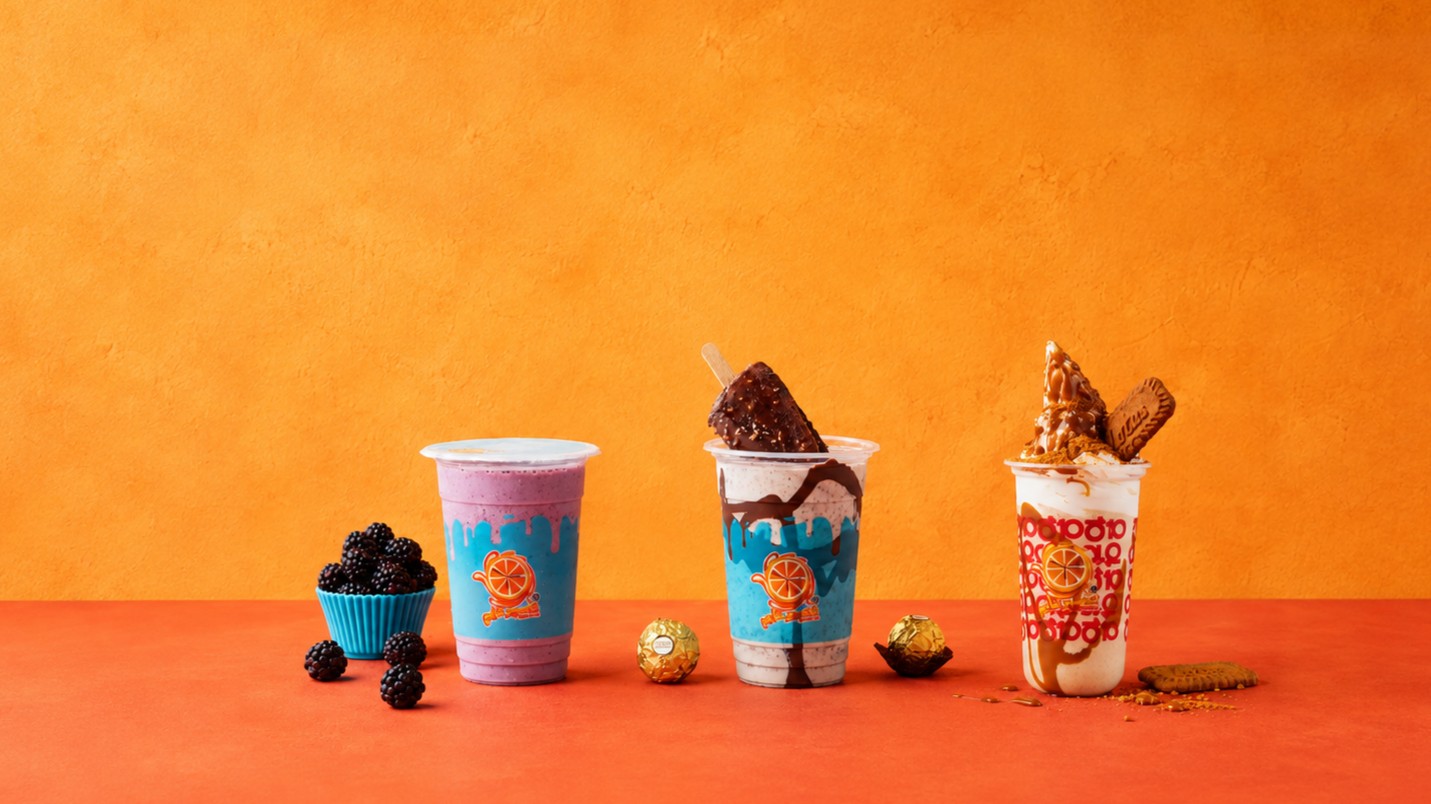 Three Juice Time shakes, blackberry, Ferrero chocolate and Lotus Biscoff, on an orange backdrop